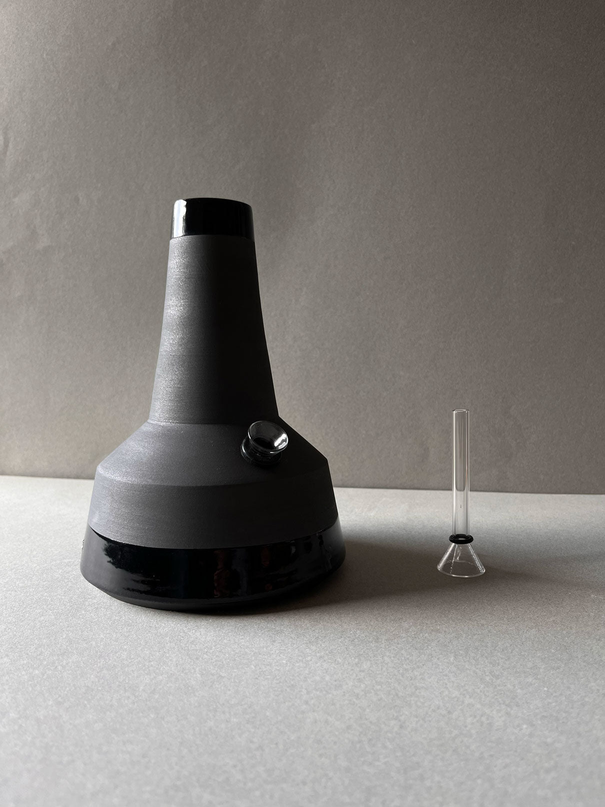 White stoneware, hand painted black matte exterior with a clear glazed interior, rim and base.