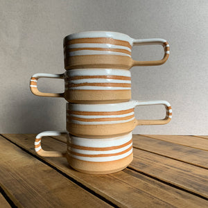 Brown stoneware espresso cup with glossy white interior and decorative stripes, group shot
